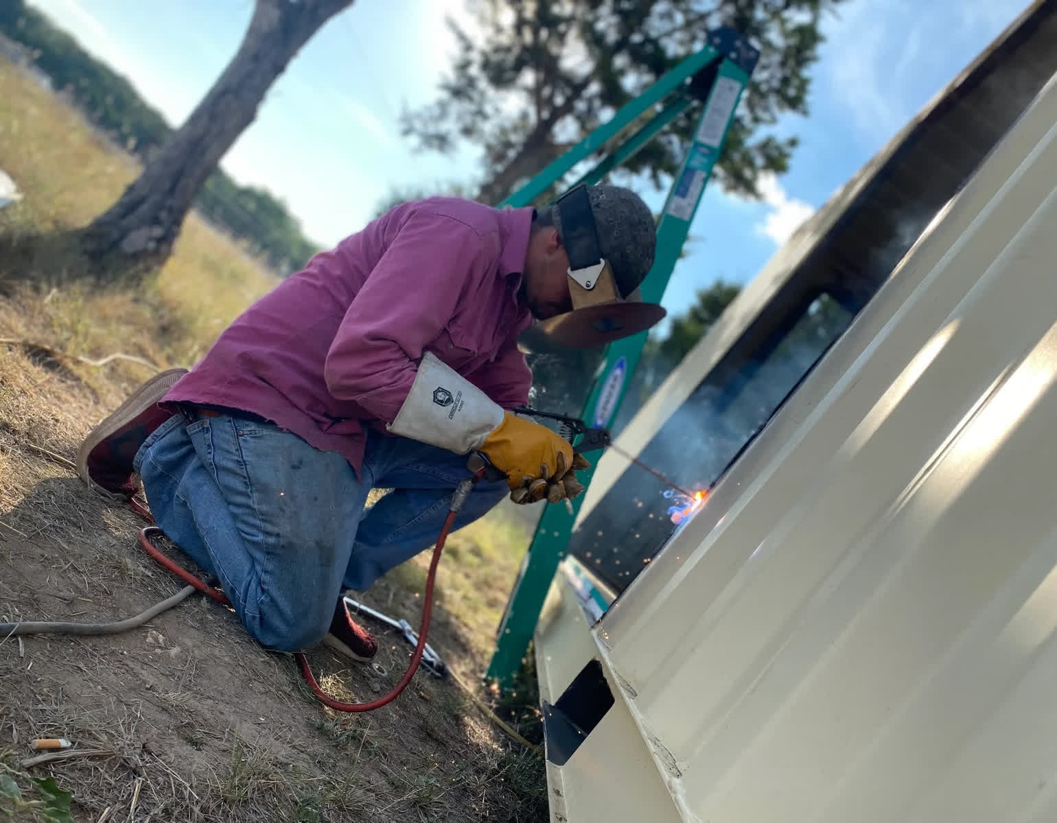 LR Mobile Welding on-site, MIG welding metal panel with sparks, in the Texas Hill Country